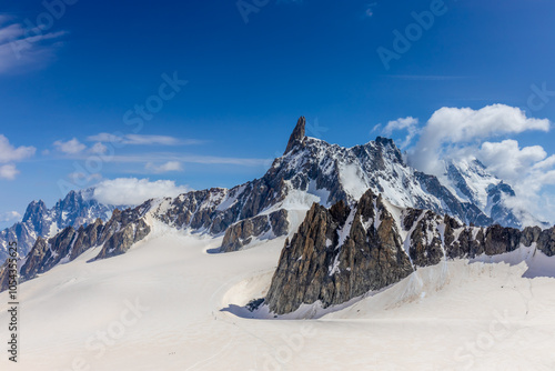 Snow covered mountains and rocky peaks of the Alps from the sky way between Chamonix and Courmayeur in Italy and France Alps. Dent du Gigante rocky towering peak and glacier at the bottom of Montblanc