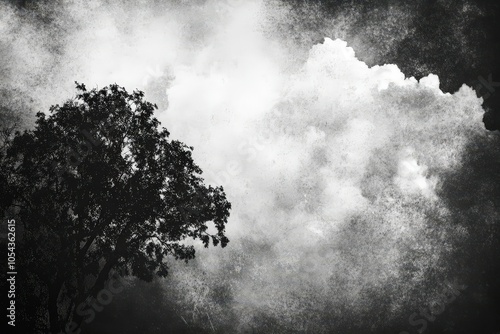 A solitary tree stands against a dramatic sky filled with thick clouds during a moody afternoon in a rural landscape