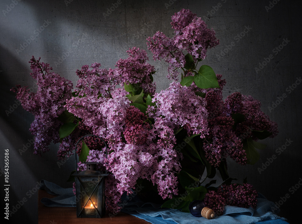 A beautiful arrangement of lilac flowers is displayed in a white vase on a table. The flowers are in full bloom and their vibrant color creates a sense of freshness and vitality.