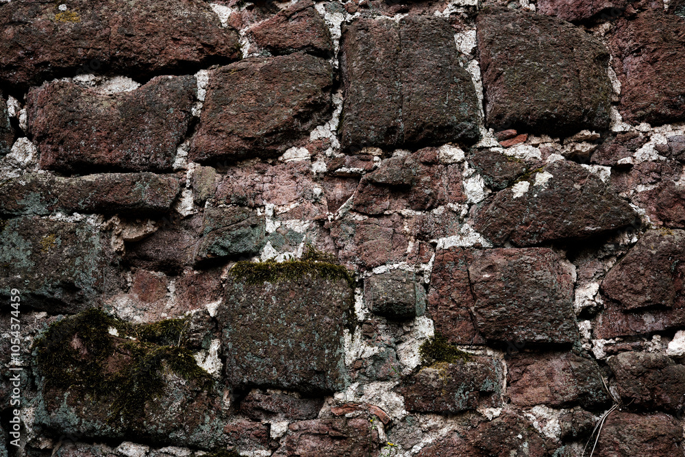 A wall made of stone with a rough texture. The wall is brown and white