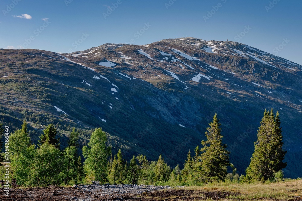 Obraz premium Beautiful landscape of snow-capped mountains under a clear blue sky with scattered clouds.