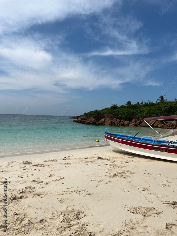 Peaceful Beach with Clear Waters and a Docked Boat Peaceful Beach with Clear Waters and a Docked Boat