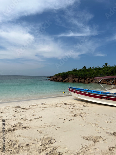 Peaceful Beach with Clear Waters and a Docked Boat