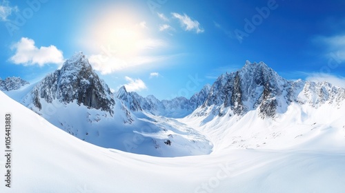 A panoramic view of a snow-covered mountain range with a bright sun shining in the sky.