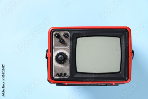 Retro tv set on light blue background, top view. Space for text