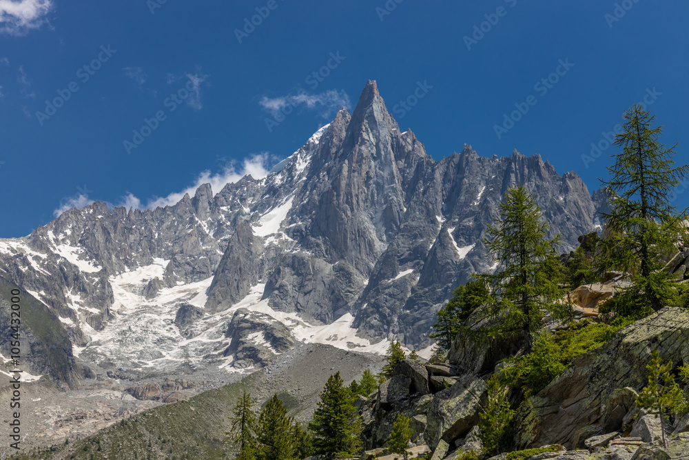 Obraz premium The Petit Dru mountain summit displays rugged peaks and rocky formations against clear sky. Rocky peak of Aiguilles de Dru, les Drus in Chamonix Alps