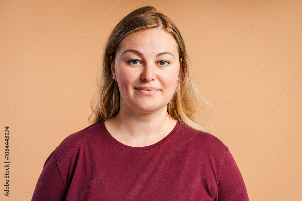 Pretty plus size Caucasian woman posing looking at camera, isolated on beige Pretty plus size Caucasian woman posing looking at camera, isolated on beige