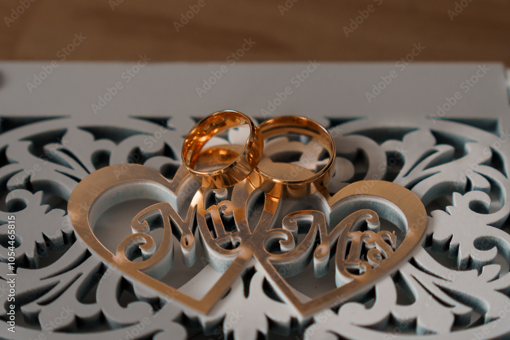 A Close-Up View of Golden Wedding Rings Resting on a Decorative Mr and Mrs Heart A Close-Up View of Golden Wedding Rings Resting on a Decorative Mr and Mrs Heart