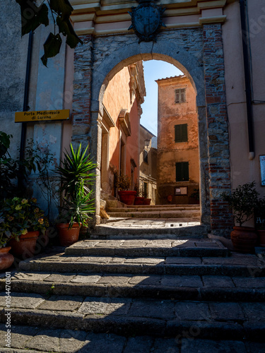 Torbogen in der historischen Altstadt von Marciana, Elba, mit Sonnenstrahlen, die durch den Bogen scheinen – Mediterraner Charme und antike Architektur photo