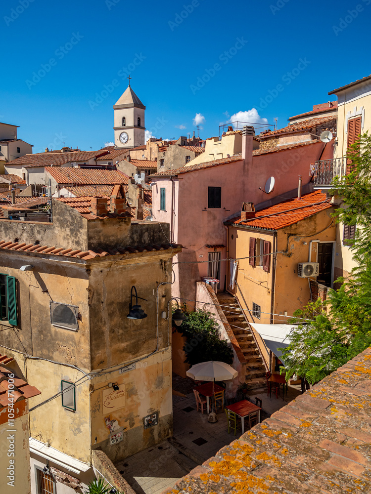 Fotografie Bergstadt Capoliveri auf Elba: Panoramablick über Hausdächer unter blauem Himmel