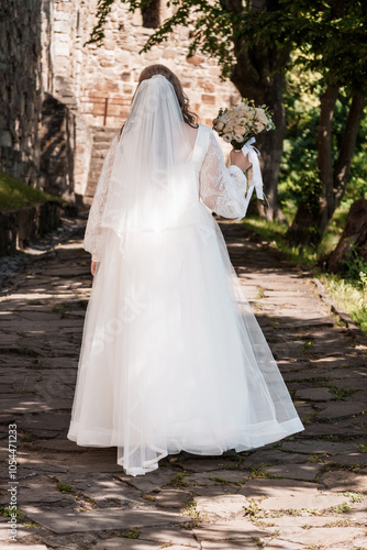 Elegant Bride Walking Down a Stone Pathway Surrounded by Nature