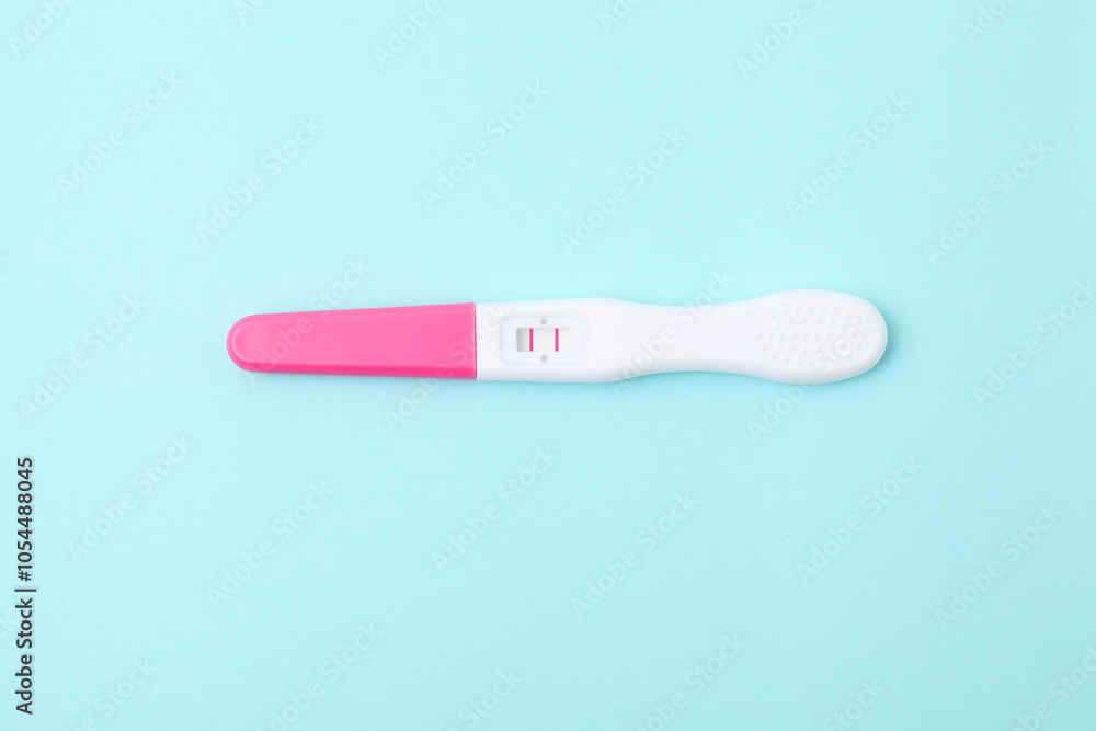 One pregnancy test on light blue background, above view One pregnancy test on light blue background, above view