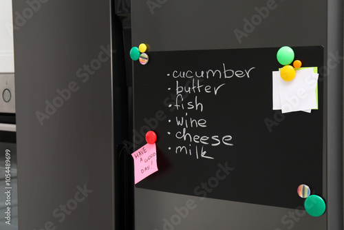 Magnetic board with shopping list and notes on refrigerator in kitchen photo