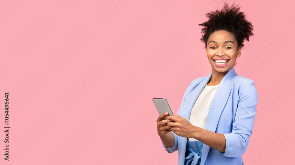 Chatting With Friends. Happy black woman holding mobile phone, looking at camera over pink studio wall, free space Chatting With Friends. Happy black woman holding mobile phone, looking at camera over pink studio wall, free space