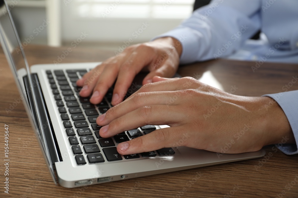 Businessman using laptop at wooden table, closeup. Modern technology Businessman using laptop at wooden table, closeup. Modern technology