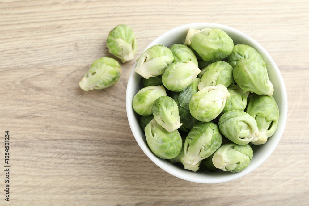 Fresh green Brussels sprouts in bowl on wooden table, top view. Space for text Fresh green Brussels sprouts in bowl on wooden table, top view. Space for text