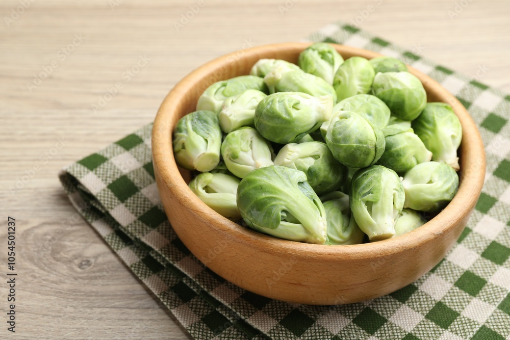 Fresh green Brussels sprouts in bowl on wooden table, closeup Fresh green Brussels sprouts in bowl on wooden table, closeup
