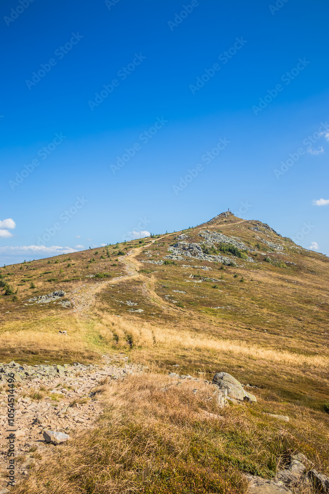 A Beautifully Serene Mountain Landscape Surrounded by a Clear and Bright Blue Sky A Beautifully Serene Mountain Landscape Surrounded by a Clear and Bright Blue Sky