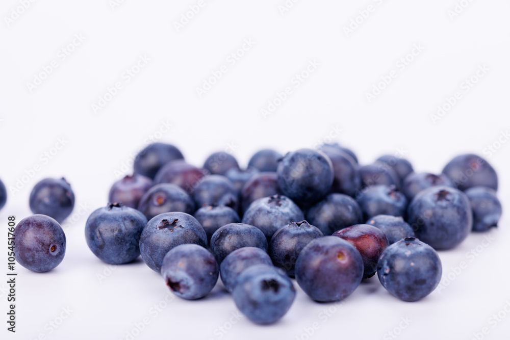 Stunning close-up of blueberries piled together on a clean white background, emphasizing their natural beauty and juicy texture in detail Stunning close-up of blueberries piled together on a clean white background, emphasizing their natural beauty and juicy texture in detail