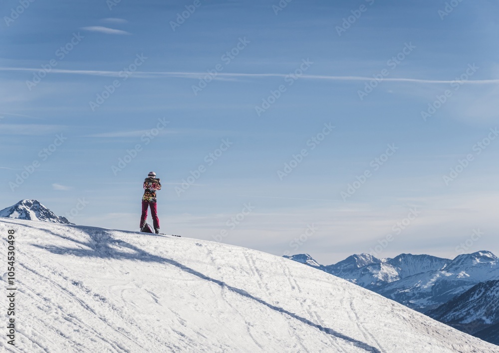 Person on snowy mountain peak admiring scenic view Person on snowy mountain peak admiring scenic view