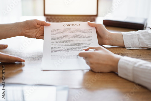 Businesswoman lawyer pointing into contract special points admitting something for colleague or client at the wooden desk in office. Business people teamwork and partnership, meeting concept