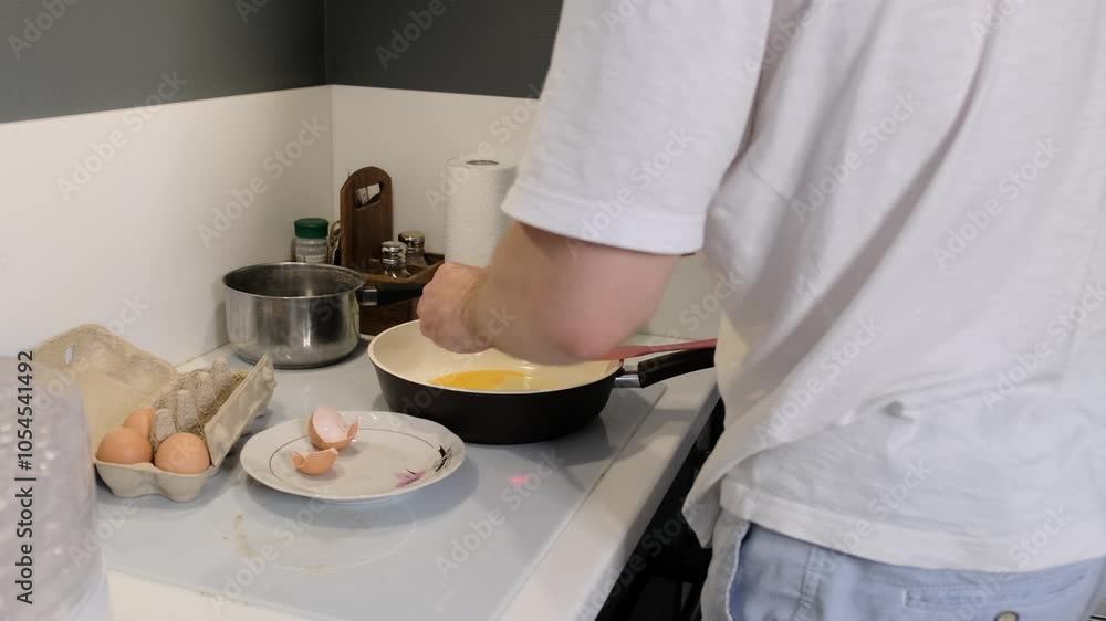 person cracks an egg into a frying pan while preparing breakfast in the kitchen. This image highlights the simplicity of cooking at home and the importance of fresh ingredients. person cracks an egg into a frying pan while preparing breakfast in the kitchen. This image highlights the simplicity of cooking at home and the importance of fresh ingredients.