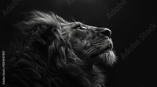 This stunning black and white profile portrait captures the majestic presence of a lion, highlighting its windswept mane and gaze into the distance with nobility.