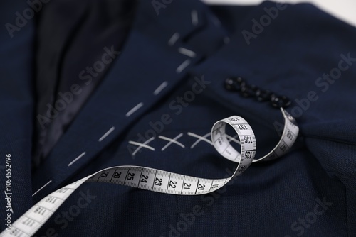 Elegant semi-ready jacket and measuring tape, closeup photo