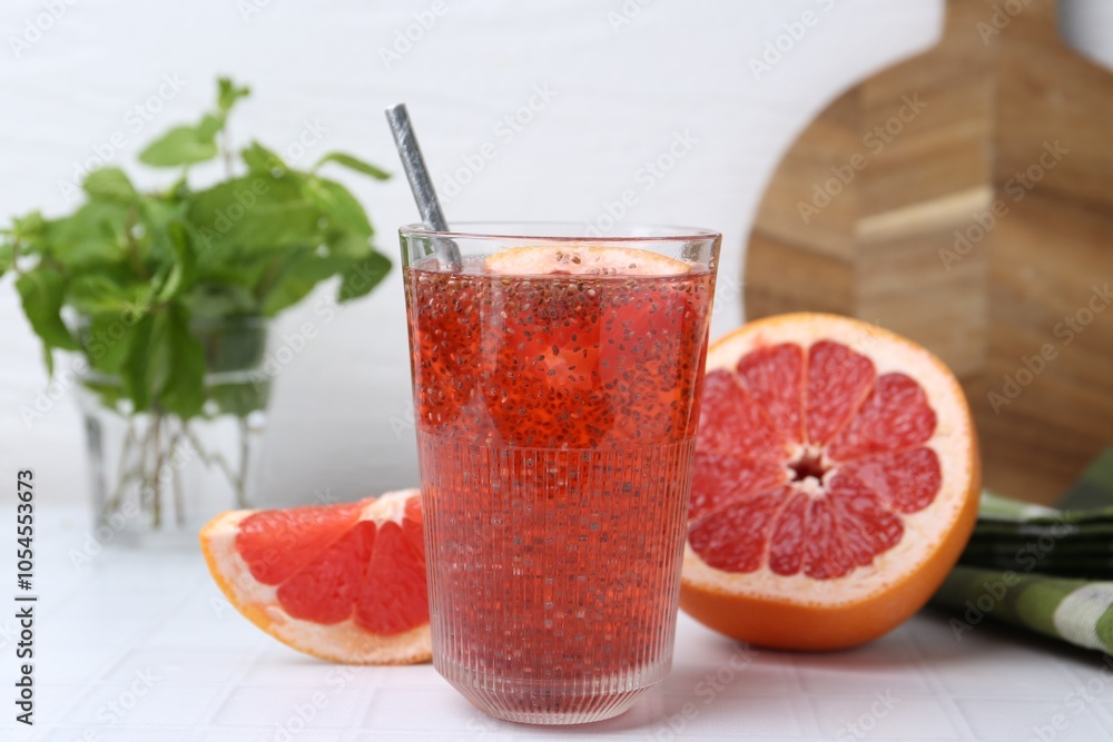Glass of drink with chia seeds and grapefruit on white tiled table, closeup Glass of drink with chia seeds and grapefruit on white tiled table, closeup