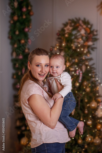 A woman holds and the child on her hand with an emotion of surprise. A room with Christmas decor