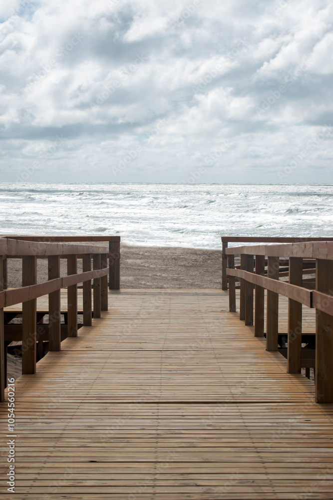 Wooden bridge that takes you to the beach. View of the sea. Natural landscapes. Wooden bridge that takes you to the beach. View of the sea. Natural landscapes.