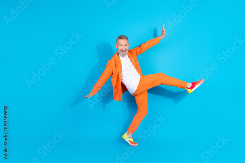 Full body portrait of modern stylish aged man dance have fun wear orange costume isolated on blue color background