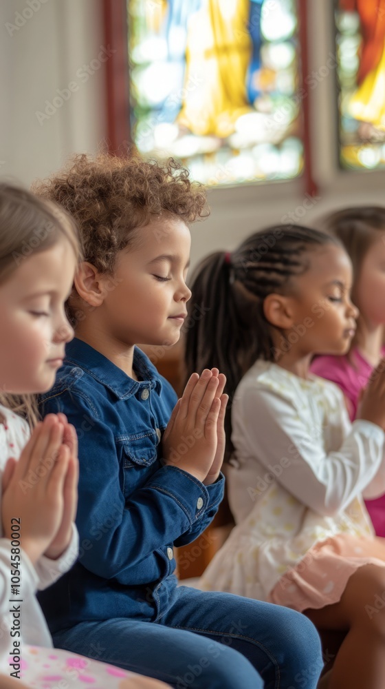 Fototapeta premium Children in Prayer at a Church with Stained Glass Windows