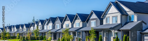 A row of modern houses with blue skies and greenery.