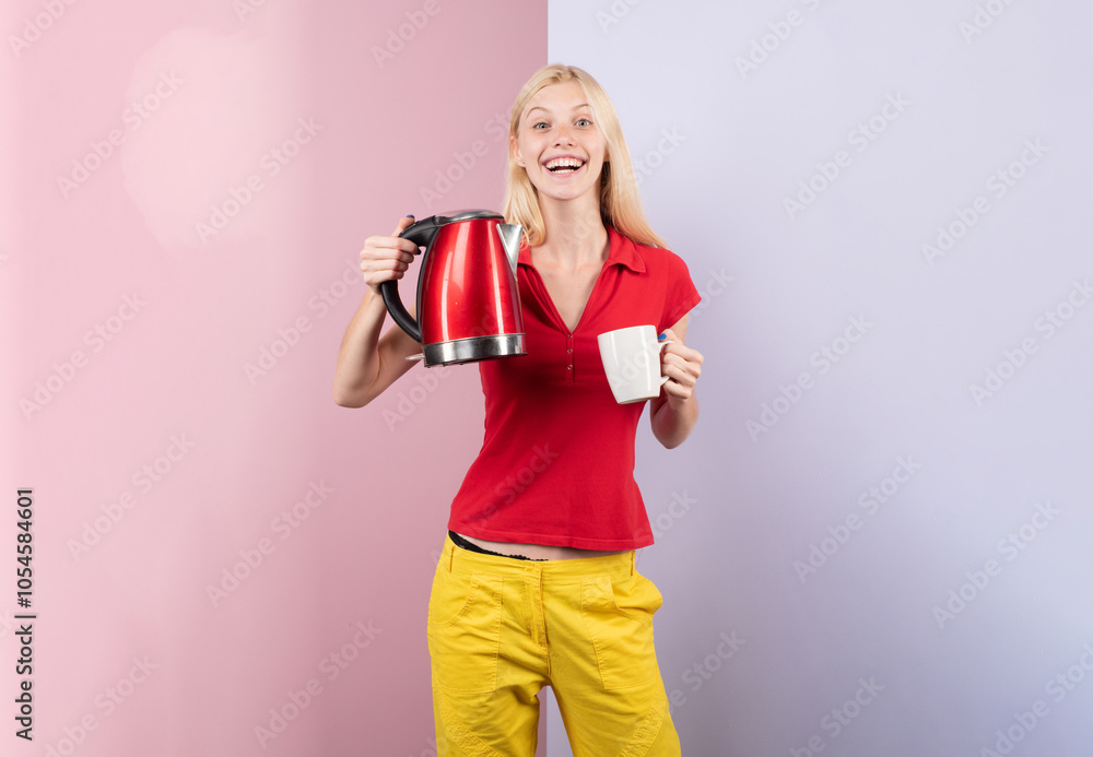Hot beverage. Happy smiling attractive young woman housewife pouring and making tea using electric kettle for tea or coffee in color studio background. Funny girl using electric kettle. Hot beverage. Happy smiling attractive young woman housewife pouring and making tea using electric kettle for tea or coffee in color studio background. Funny girl using electric kettle.