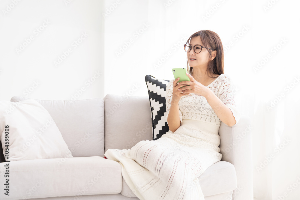 部屋でスマホを見る女性 部屋でスマホを見る女性