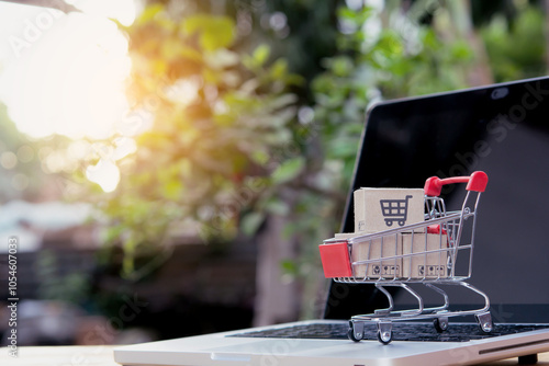 Shopping online. cardboard box with a shopping cart logo in a trolley on laptop keyboard. Shopping service on The online web. offers home delivery photo