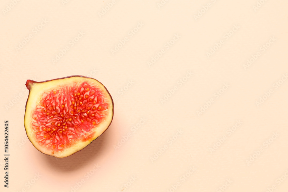 Half of fresh juicy fig on pale pink background