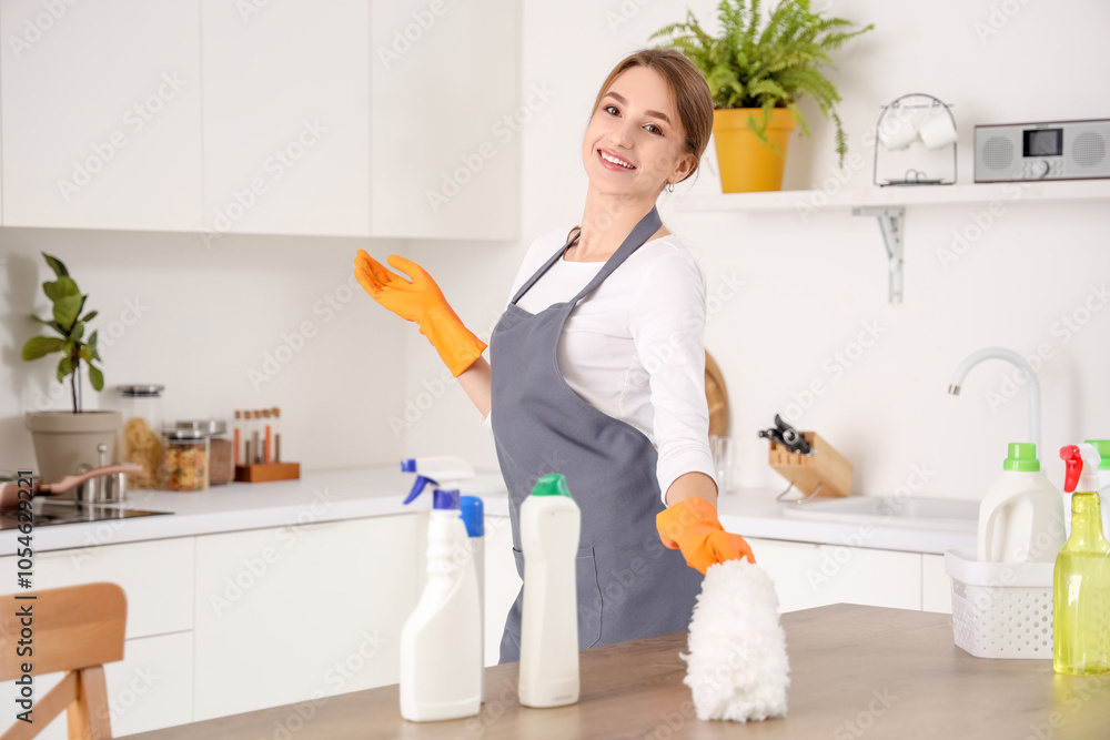 Female janitor cleaning table with pp-duster in kitchen Female janitor cleaning table with pp-duster in kitchen