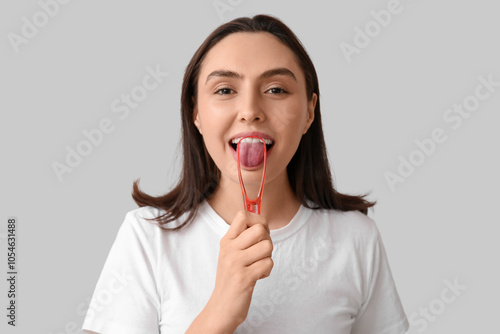 Young woman using tongue sc...