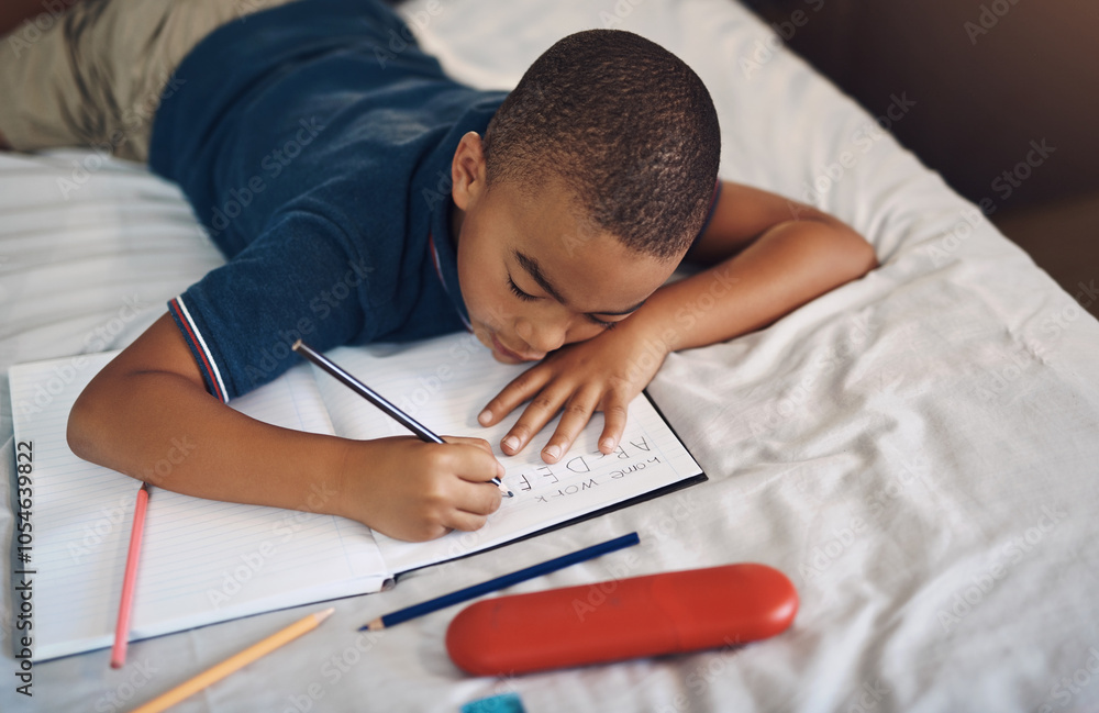 Boy, bed and writing with book for alphabet, creativity or literature for educational activity at home. Young, male person or child with pencil in house for letters, characters or homework in bedroom Boy, bed and writing with book for alphabet, creativity or literature for educational activity at home. Young, male person or child with pencil in house for letters, characters or homework in bedroom