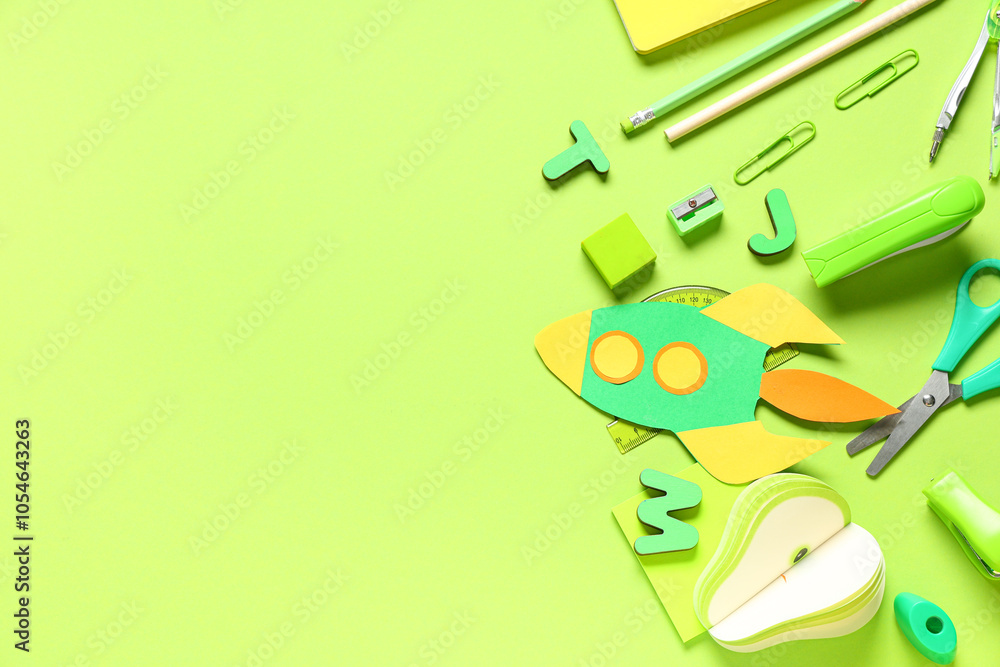 Different school stationery and paper rocket on green background Different school stationery and paper rocket on green background