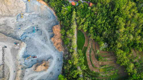 In this striking landscape, heavy machinery dominates as it excavates the mountainside, revealing hidden treasures within. Dust clouds rise from the intense operation, showcasing the powerful intersec