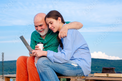 Generations of family. A grandad typing on a laptop. generation z and old generation. Daughter and father using laptop, old young generations. Generation concept. Caring about older relatives.