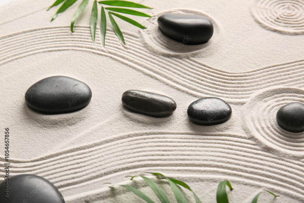 Black stones and palm leaves on light sand with lines. Zen concept Black stones and palm leaves on light sand with lines. Zen concept