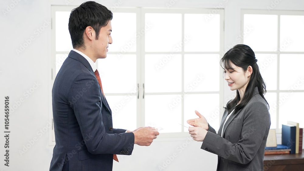 名刺交換で話をするビジネスパーソン