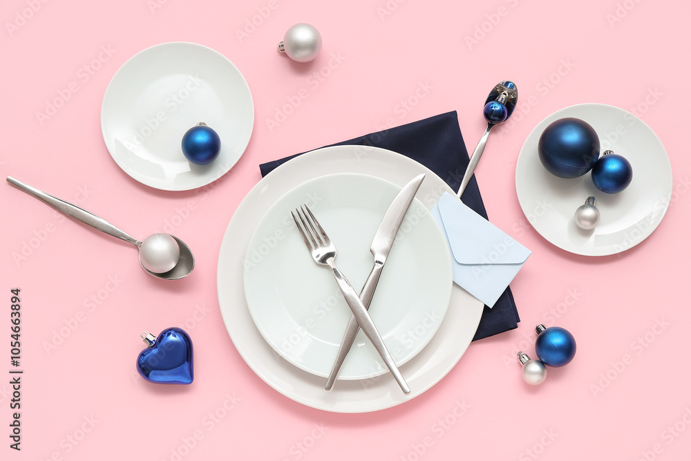 Beautiful table setting with Christmas balls and envelope on pink background Beautiful table setting with Christmas balls and envelope on pink background