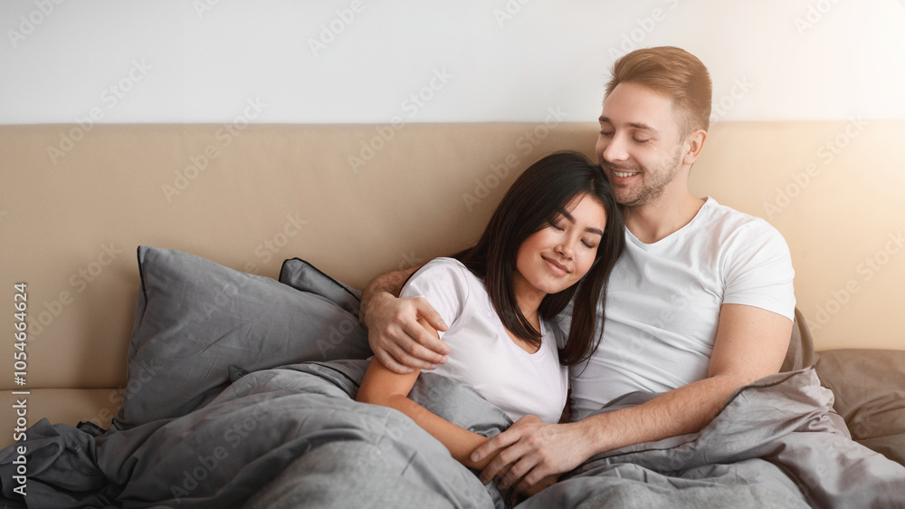 Loving Diverse Couple Hugging Lying In Bed Enjoying Weekend Together. Happy Marriage And Sex Life Concept. Loving Diverse Couple Hugging Lying In Bed Enjoying Weekend Together. Happy Marriage And Sex Life Concept.