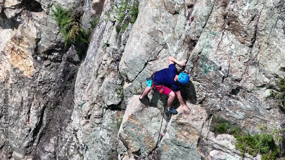 Challenging rock face conquered by determined climber Challenging rock face conquered by determined climber