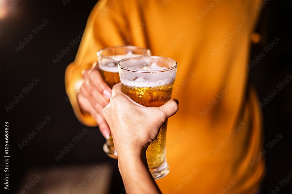 A man's hand and a woman's hand hold beer glasses in a cozy, lively evening party setting. Family and friends gather under the night sky, sharing joyful moments and laughter. A man's hand and a woman's hand hold beer glasses in a cozy, lively evening party setting. Family and friends gather under the night sky, sharing joyful moments and laughter.